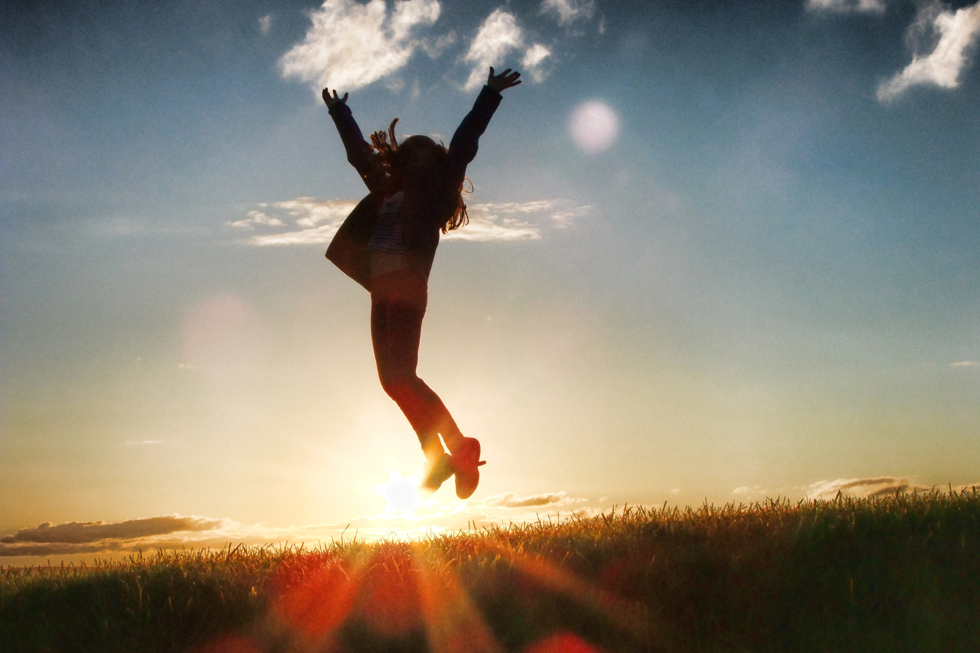 A person is jumping in the air with their arms outstretched