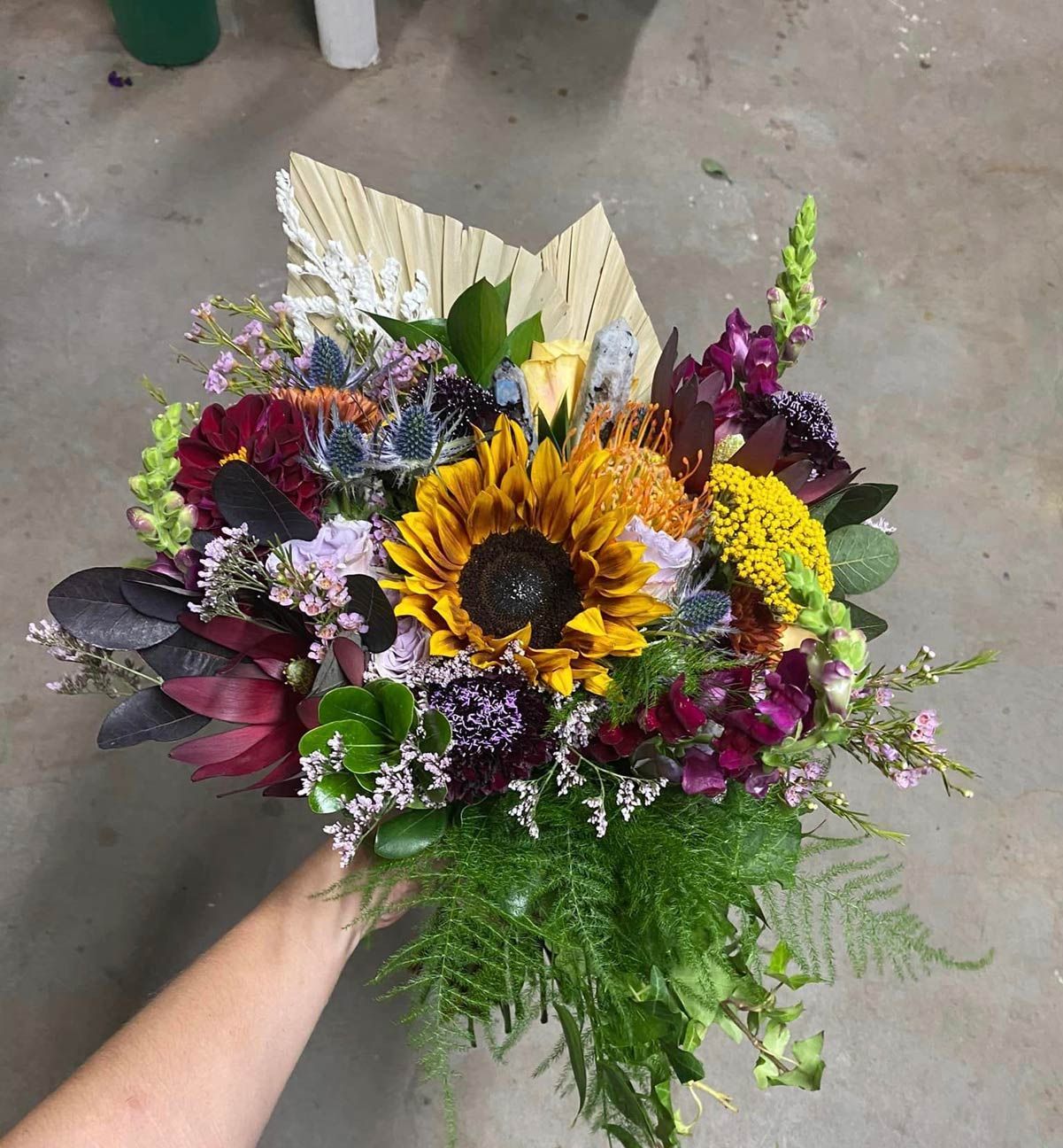 A bride and groom are posing for a picture in a field