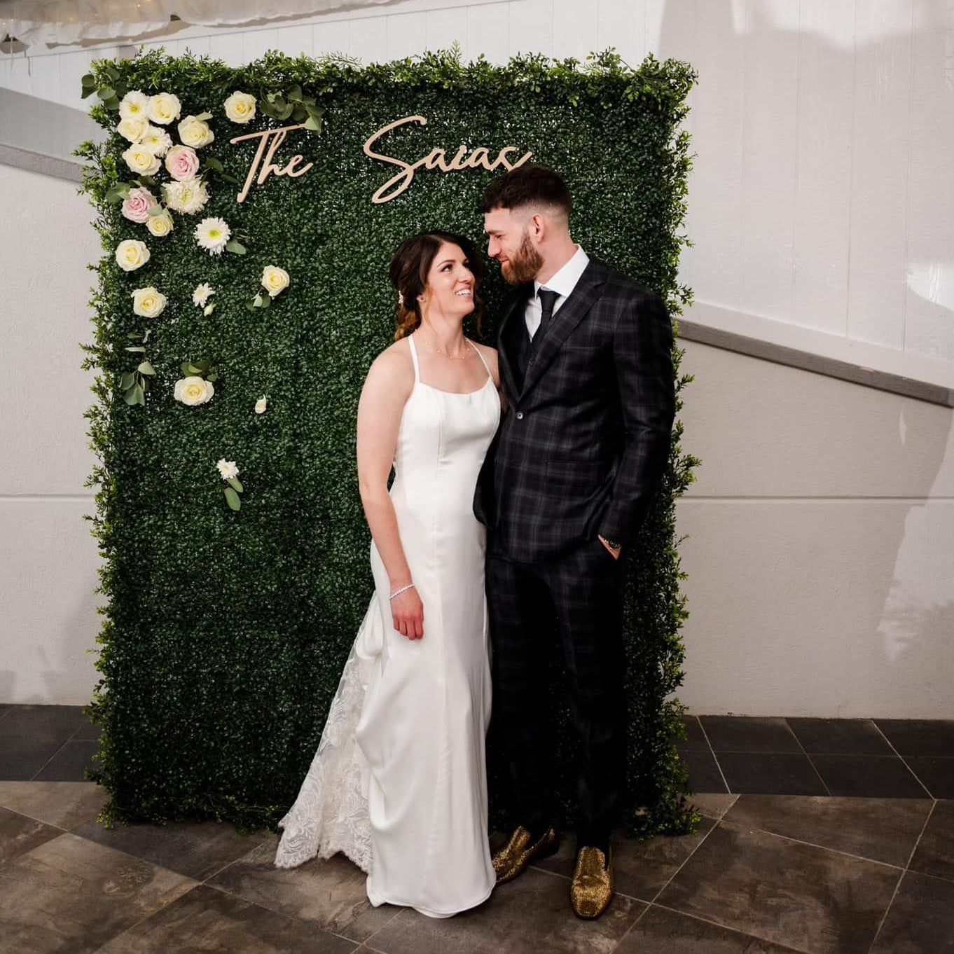 A long wooden table is set for a wedding reception