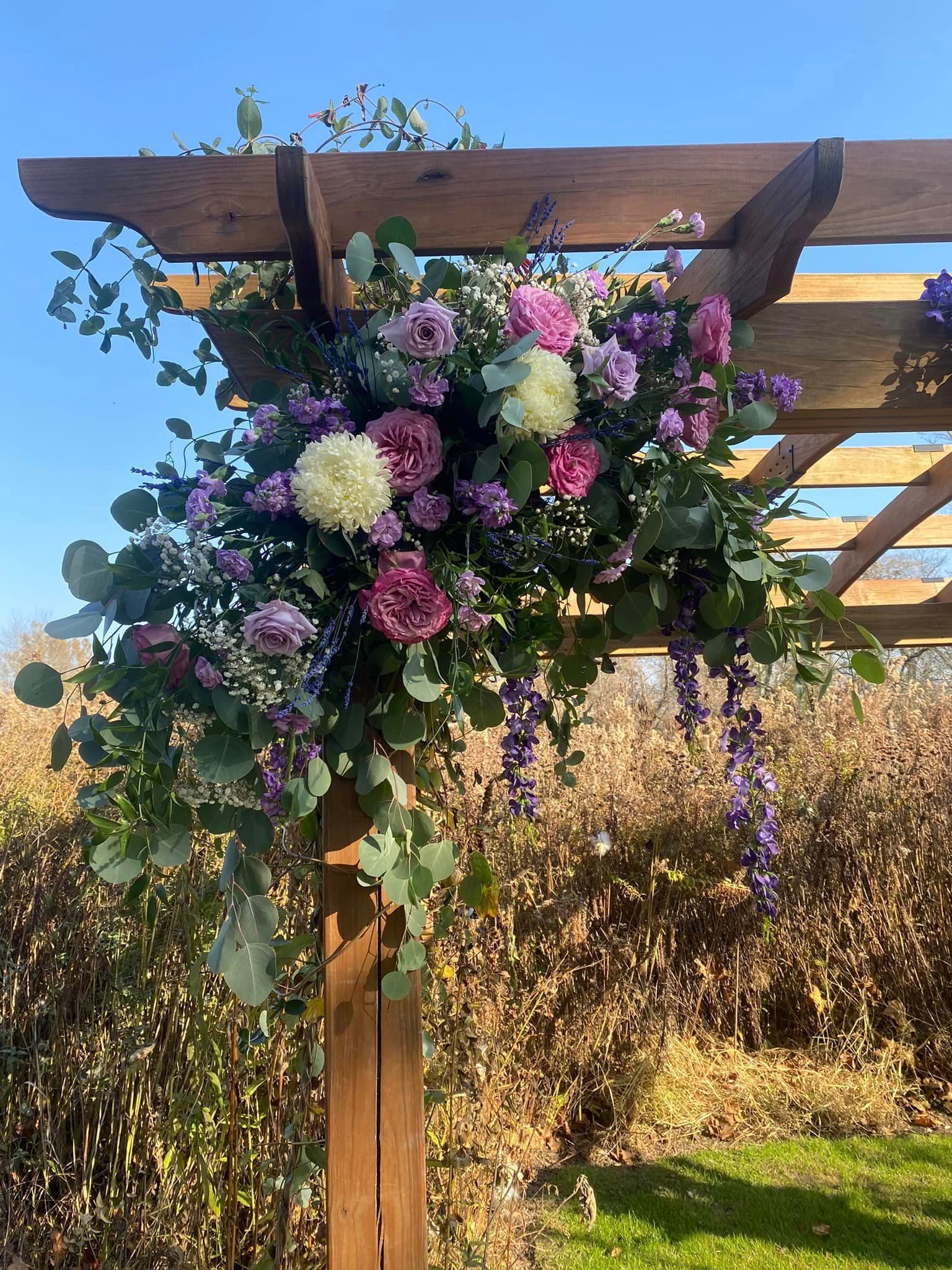 A person is holding a bouquet of flowers with a sunflower in the middle