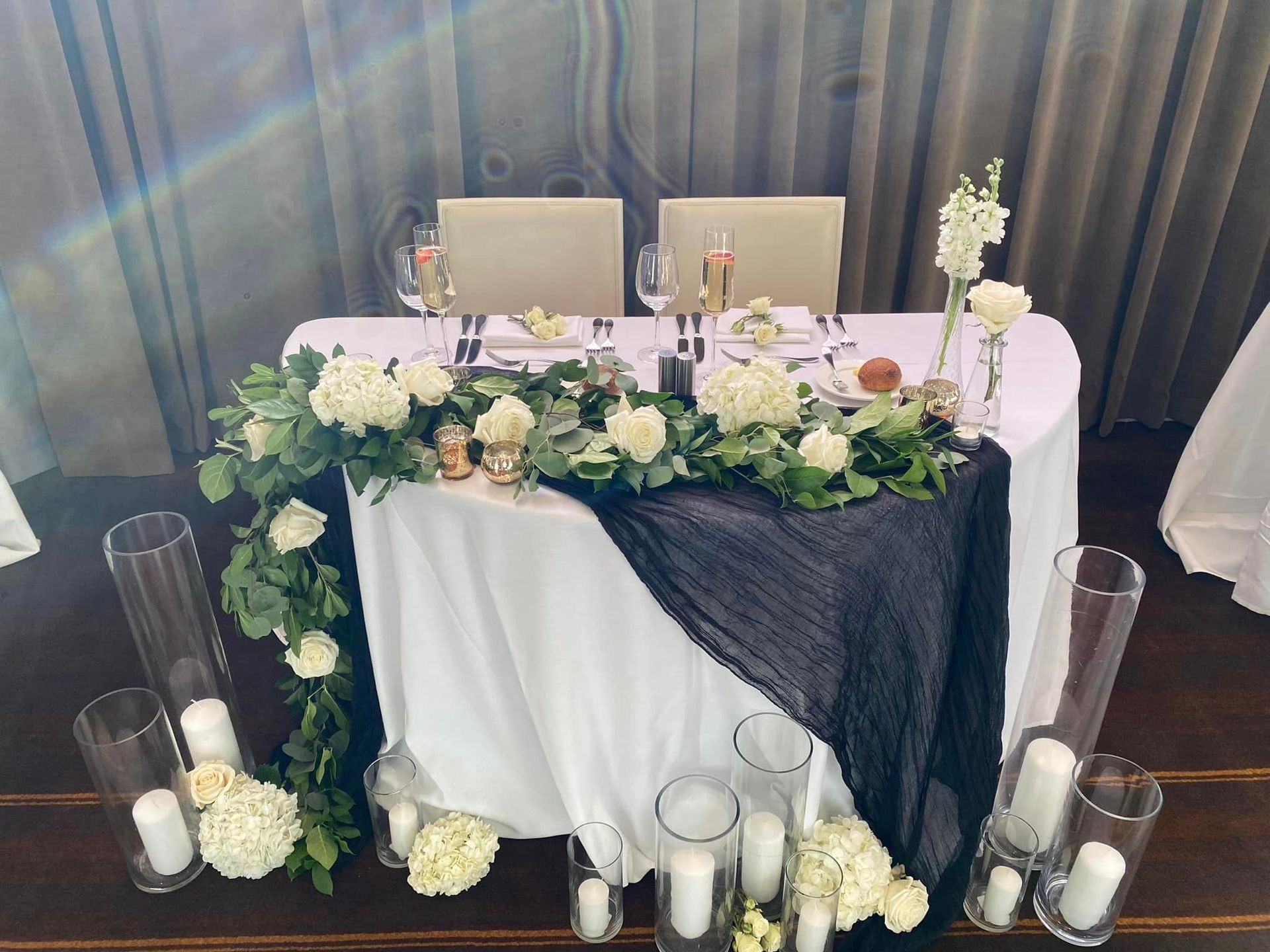 A long table with wine glasses, candles, and flowers on it