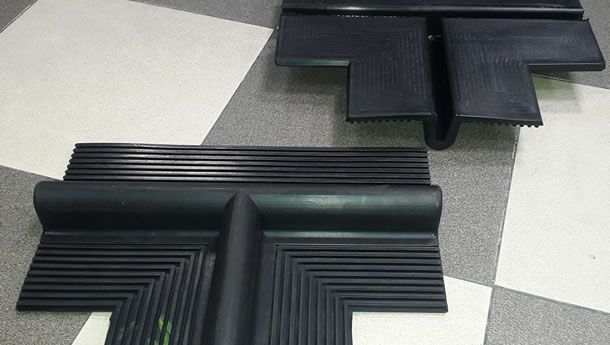 Dos piezas de goma negra están sentadas sobre un suelo a cuadros.