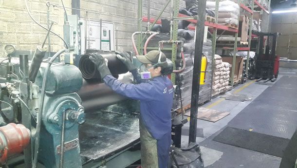 Un hombre está trabajando en una máquina en una fábrica.