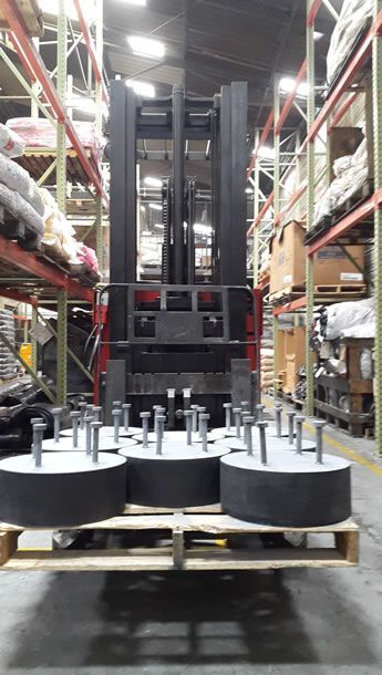 Una carretilla elevadora transporta una paleta de tuercas y tornillos en un almacén.