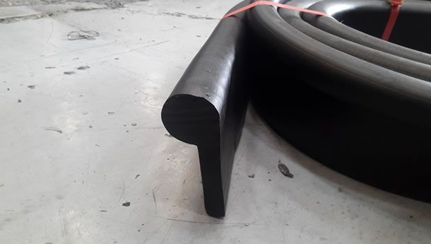 Un primer plano de una tira de goma negra sobre una superficie blanca.