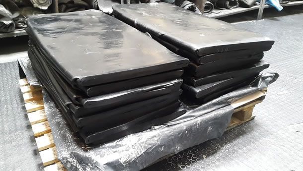 Un montón de bloques de caucho negro encima de una plataforma de madera.