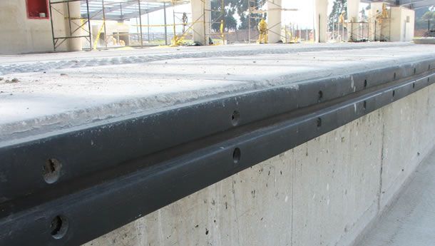 Un primer plano de un muro de hormigón con una barandilla de metal.