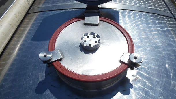 Un primer plano de un objeto metálico con un anillo de goma rojo alrededor