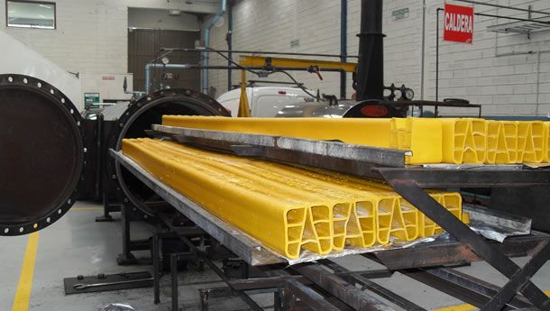 Un montón de piezas de metal amarillas están colocadas una encima de la otra en una fábrica.