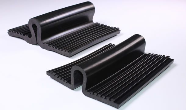 Dos piezas de goma negra están colocadas sobre una superficie blanca.