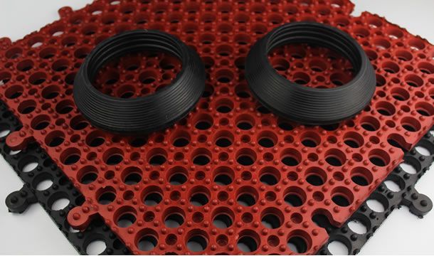 Un tapete rojo y negro con dos anillos negros encima