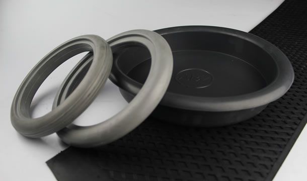 Tres anillos de goma están colocados encima de una alfombra negra.