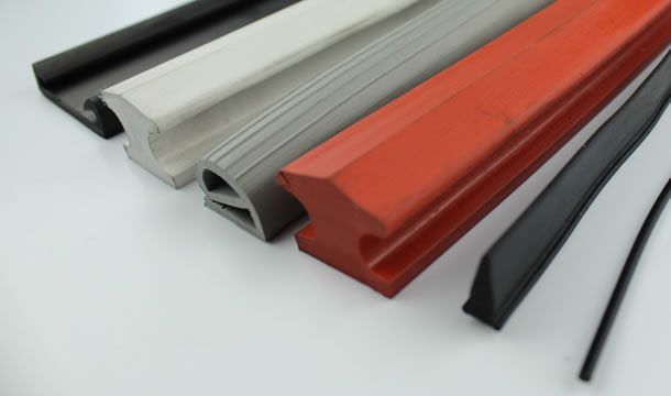 Un montón de tiras de goma de diferentes colores sobre una superficie blanca