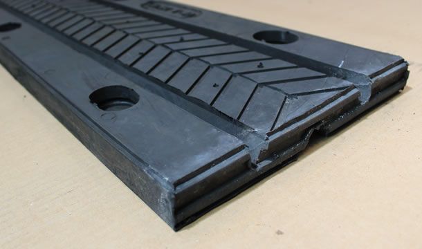 Sobre una mesa hay un trozo de goma negra con agujeros.