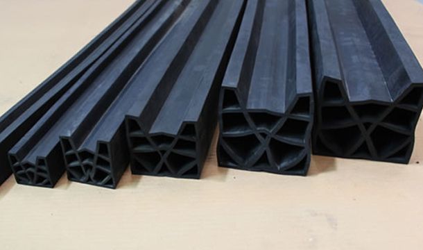 Un montón de tubos de goma negros están apilados uno encima del otro sobre una mesa.