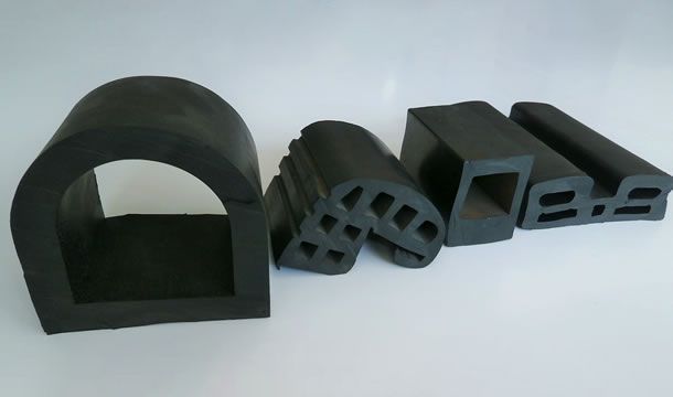 Un montón de piezas de goma negras sobre una superficie blanca