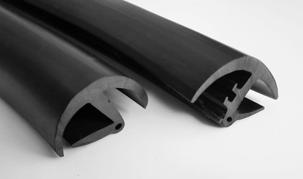 Dos tubos de goma negros están uno al lado del otro sobre una superficie blanca.