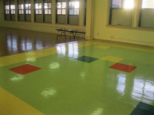 A large room with a green floor and red yellow and blue squares on it