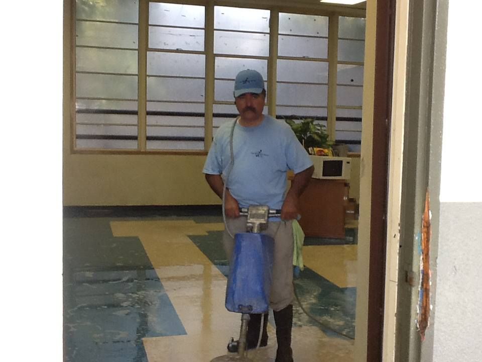A man in a blue shirt is cleaning a floor