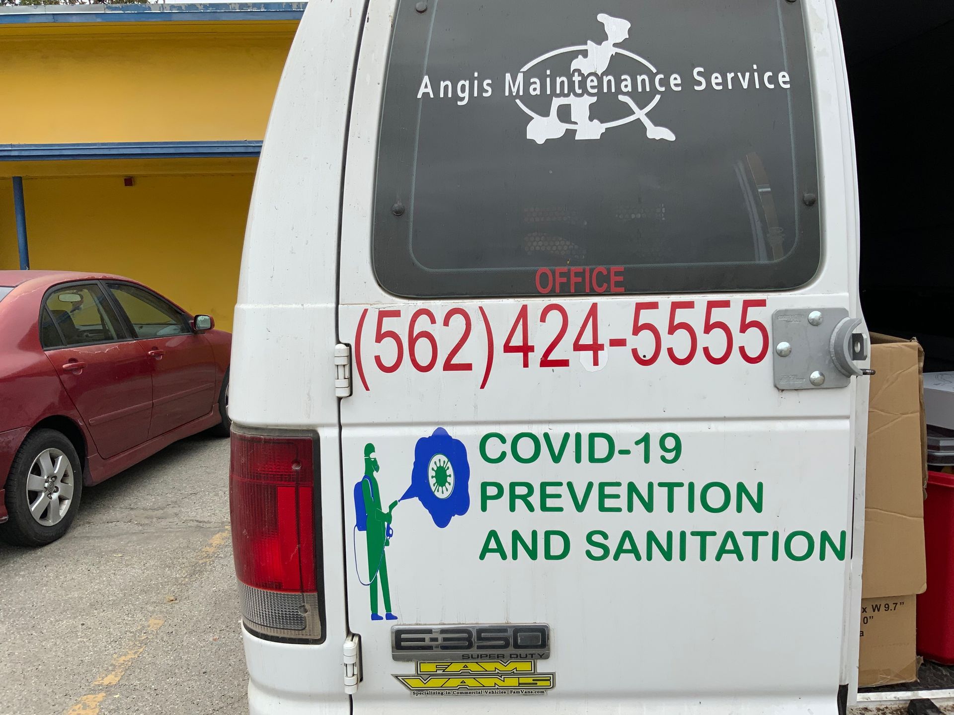 A white van with a sticker on the back that says covid-19 prevention and sanitation