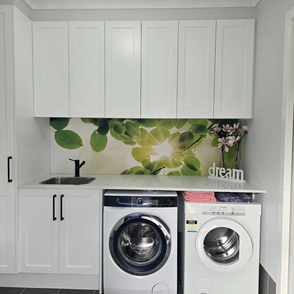 A Laundry Room With A Washer And Dryer — The Kitchen & Bathroom Doctor in Medowie, NSW