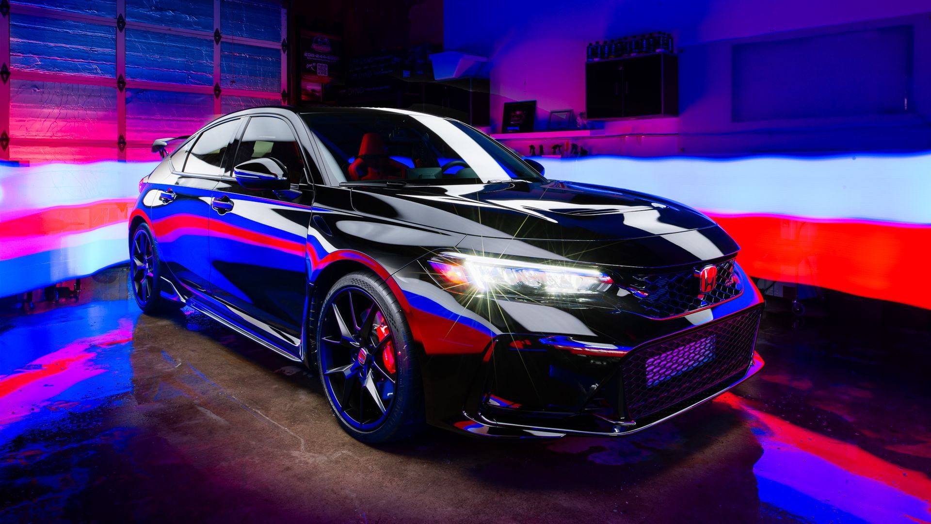 A black car is parked in a garage surrounded by colorful lights.