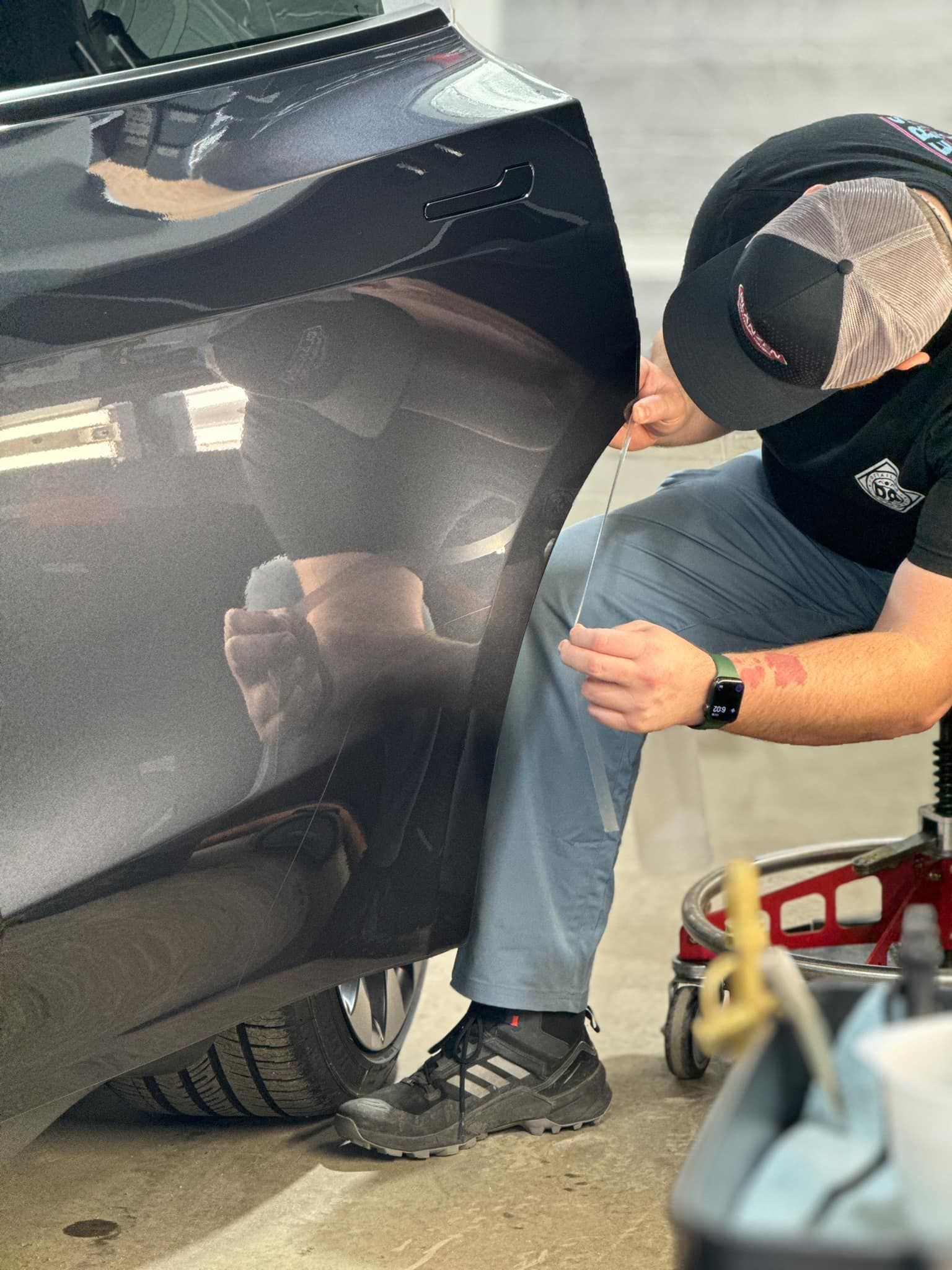 A man is working on the side of a car.