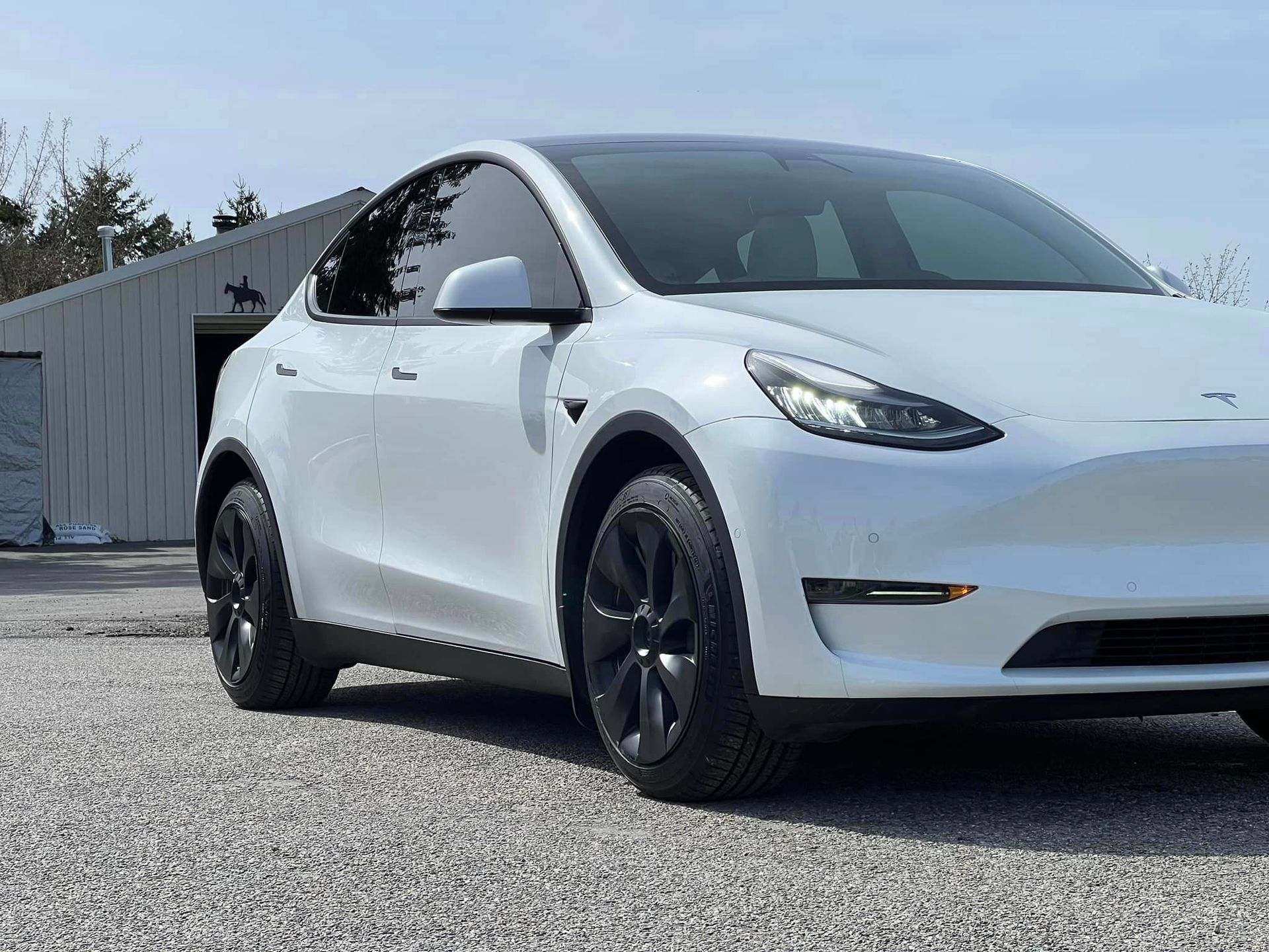 White electric SUV with black trim and red-tinted windows on a white background