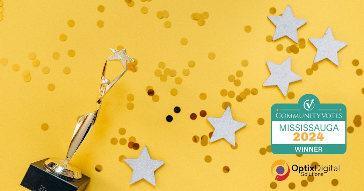 A trophy is sitting on top of a yellow table with confetti and stars.