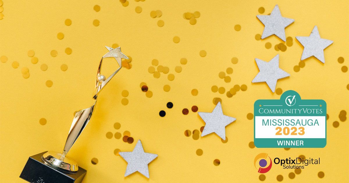 A trophy is sitting on top of a yellow table with confetti and stars.