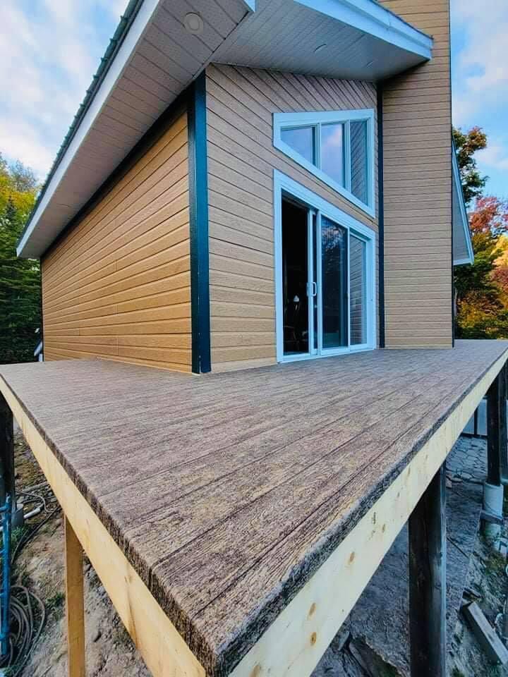 Une maison avec une grande terrasse en membrane de pvc devant.