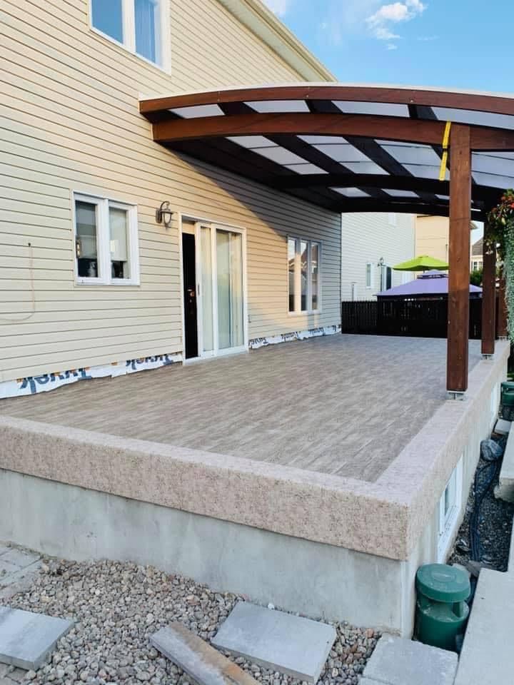 Une maison avec une terrasse en membrane de pvc et une pergola au-dessus