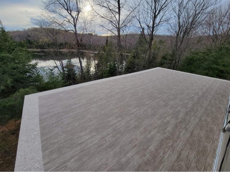 Une terrasse vue sur un lac et des arbres.