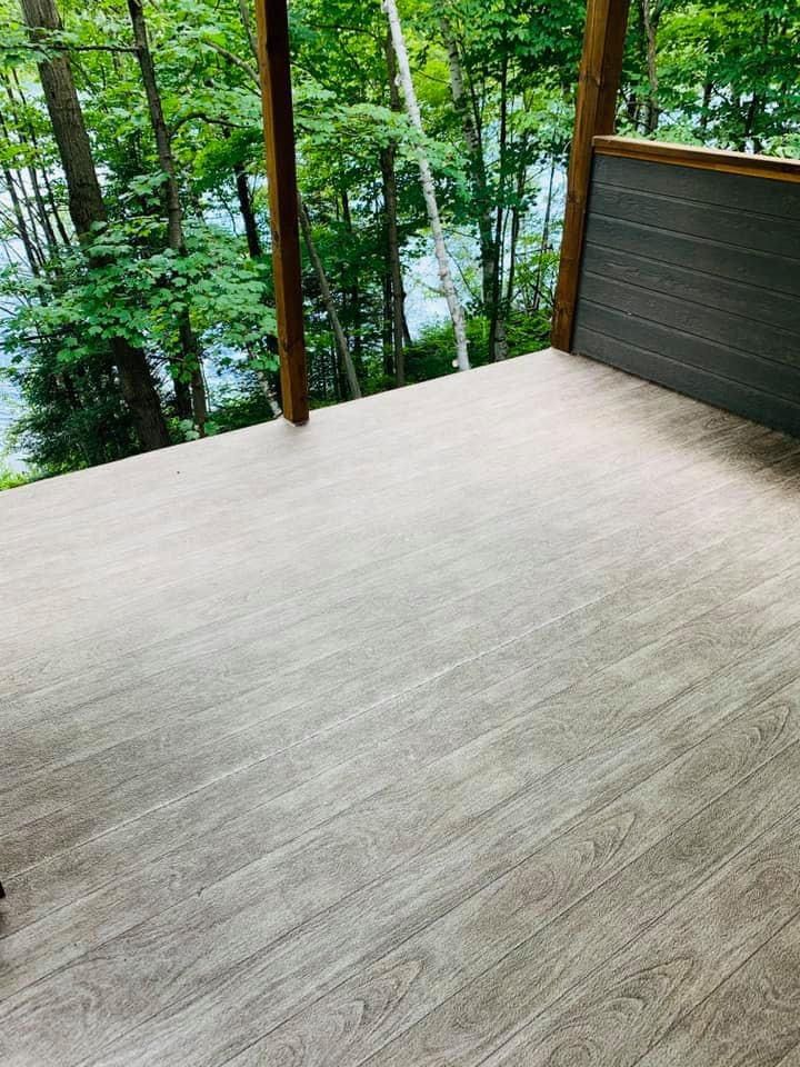 Une terrasse en membrane de pvc avec vue sur un lac et des arbres.