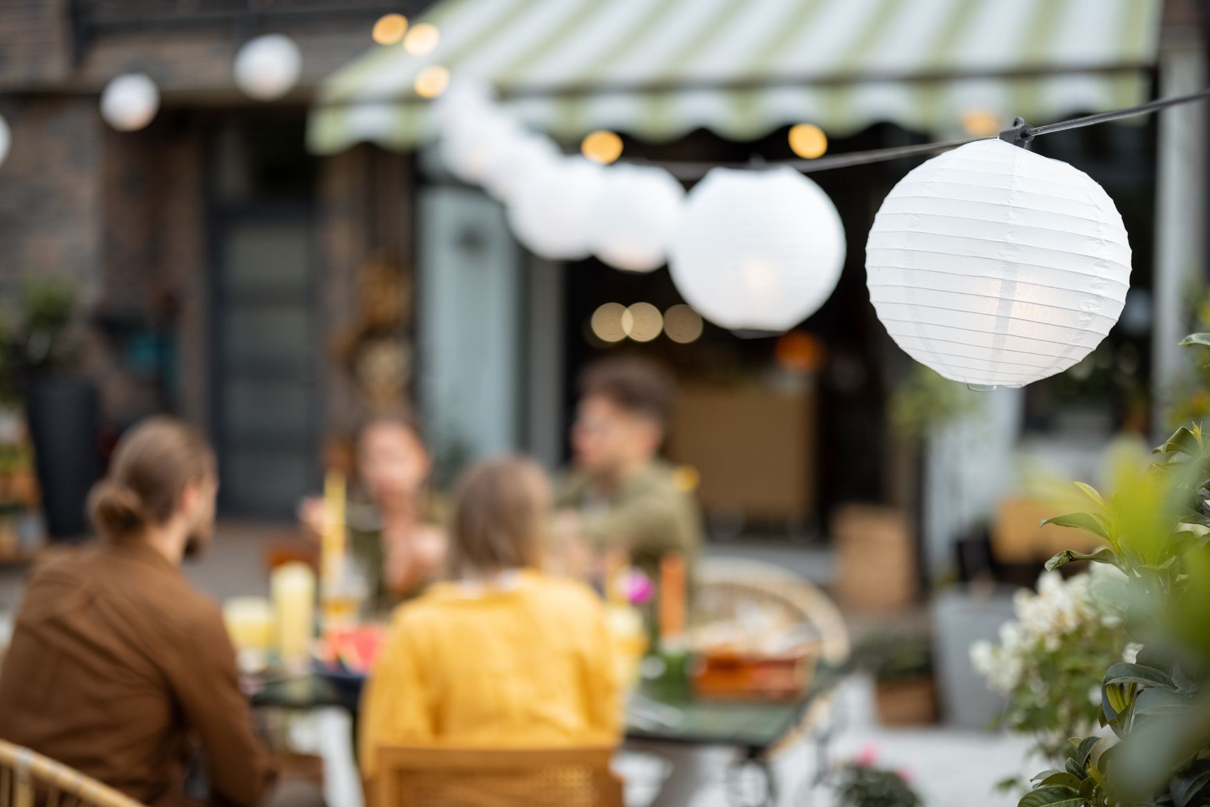 Un groupent personnes sont assis sur un patio à l'extérieur.