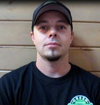 A man wearing a hat and a black shirt with the word green on it