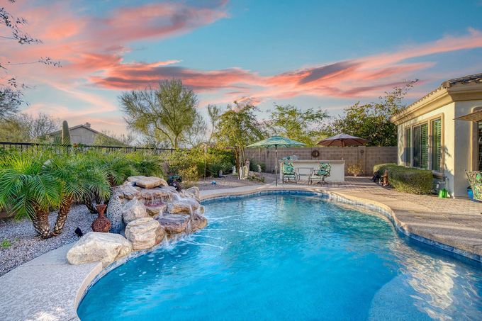 there is a large swimming pool in the backyard of a house