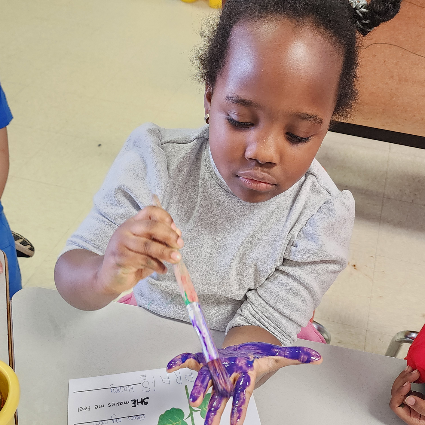 Childcare Center — A Girl Painting Her Hand Violet in Columbus, OH