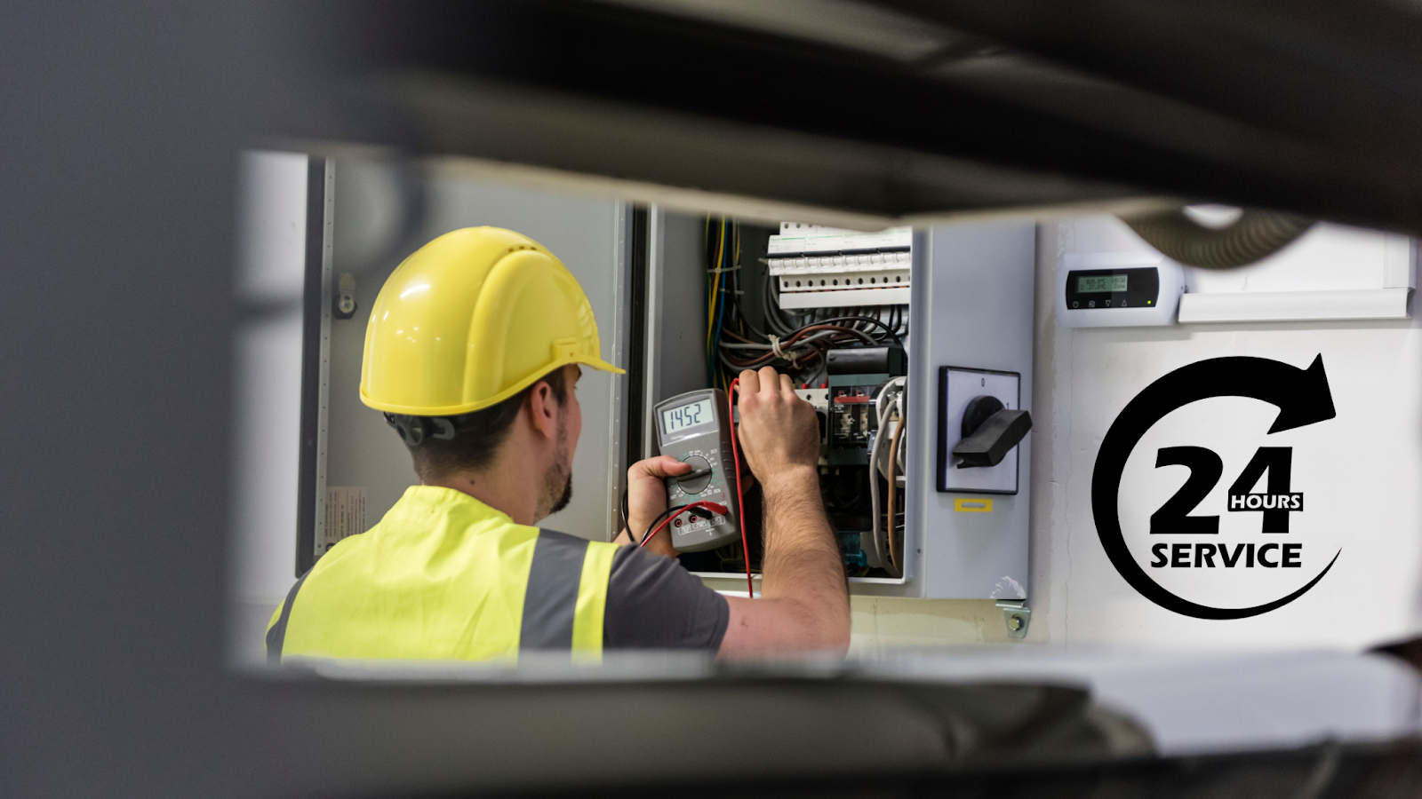 A man in a yellow hard hat is working on an electrical box. A man in a yellow hard hat is working on an electrical box.