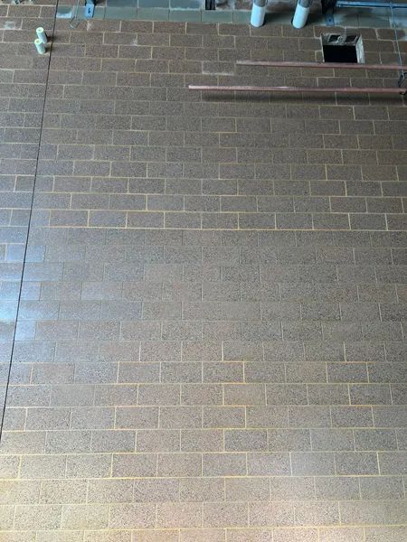 Brick wall with plumbing pipes in a construction setting.