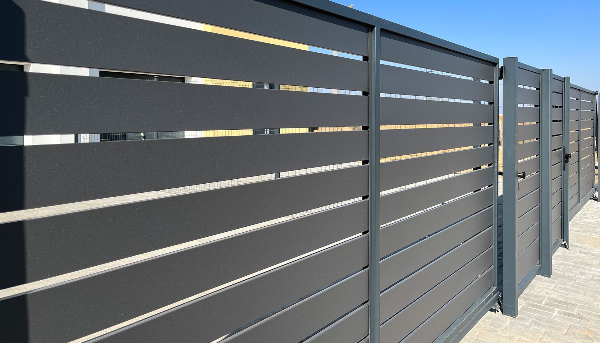 A two-story house with a large deck and covered patio. A staircase leads to the deck from the grassy yard.