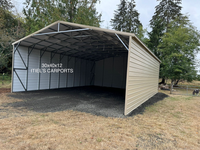 A large metal garage is sitting in the middle of a field.