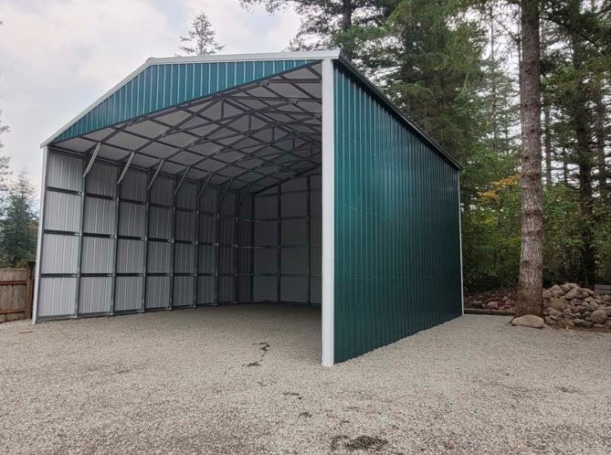 A metal garage with a white door is sitting in the middle of a dirt field.