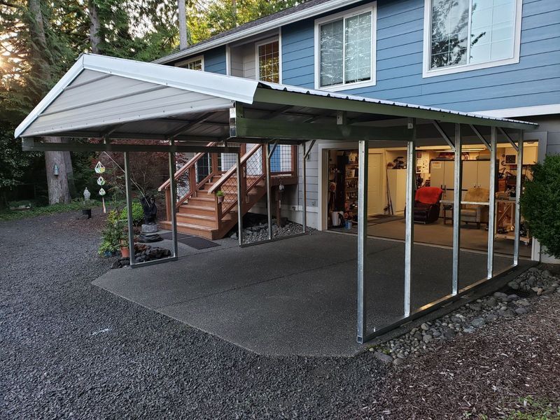 A blue house with a carport in front of it.
