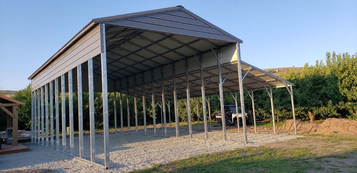 A white carport with a gravel driveway in front of a house