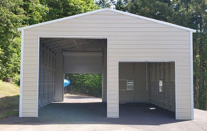 A white garage with a garage door open and a driveway leading to it.