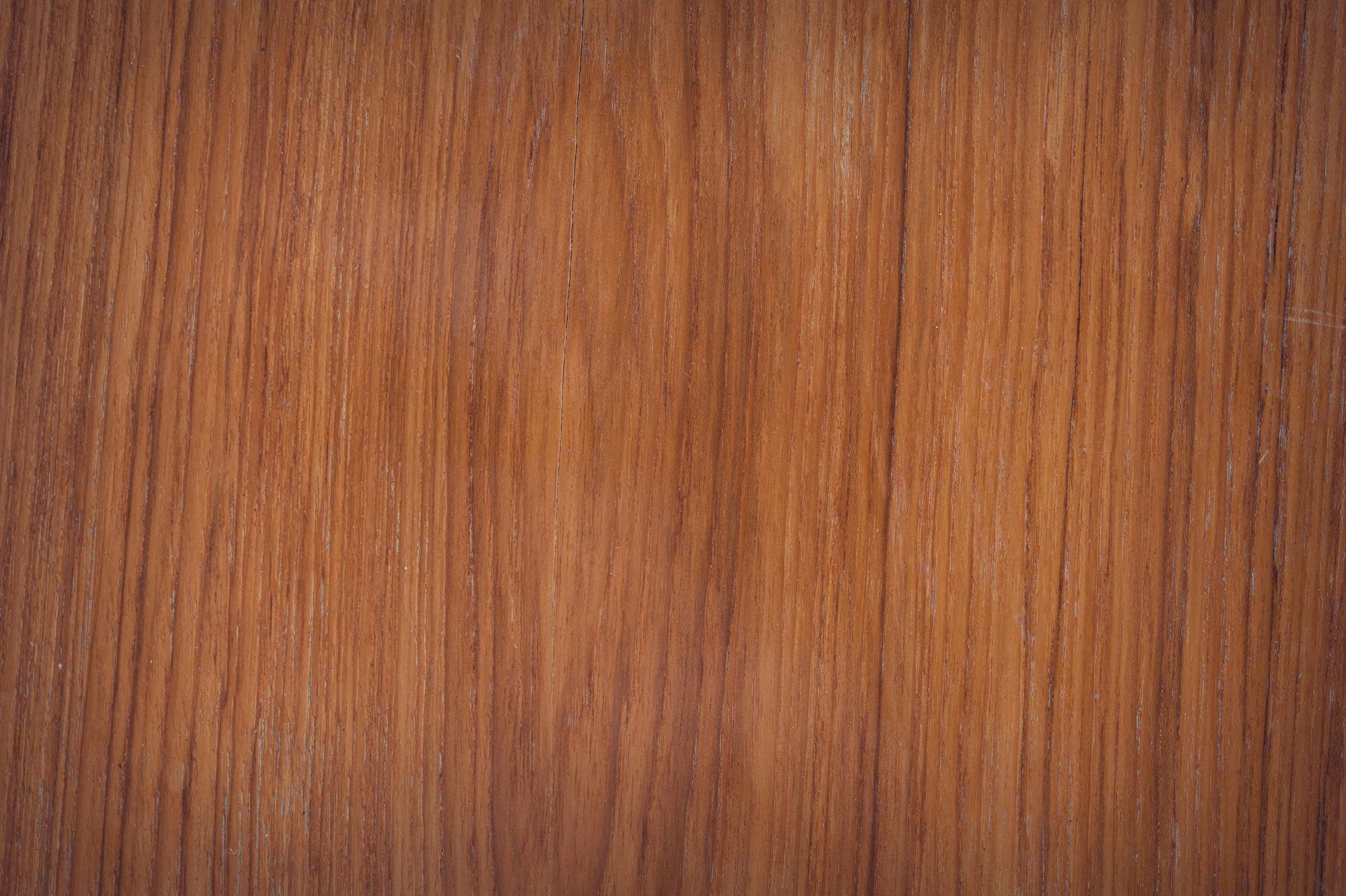 Close-up of a wooden surface, showing vertical grain lines in various shades of brown.