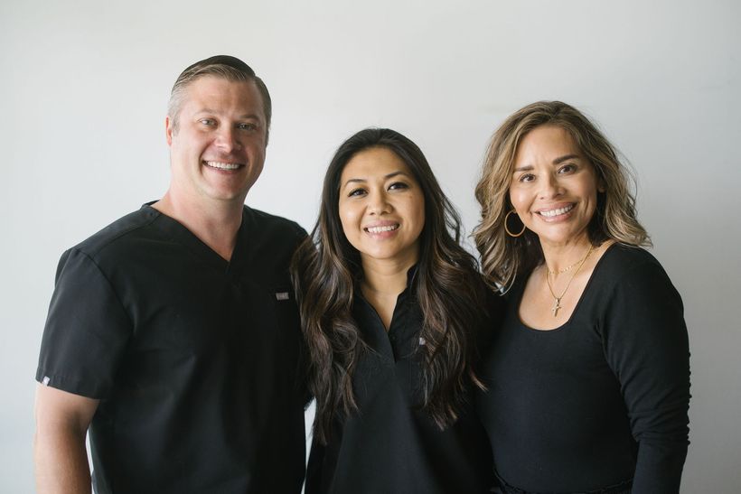 A man and two women are posing for a picture together.