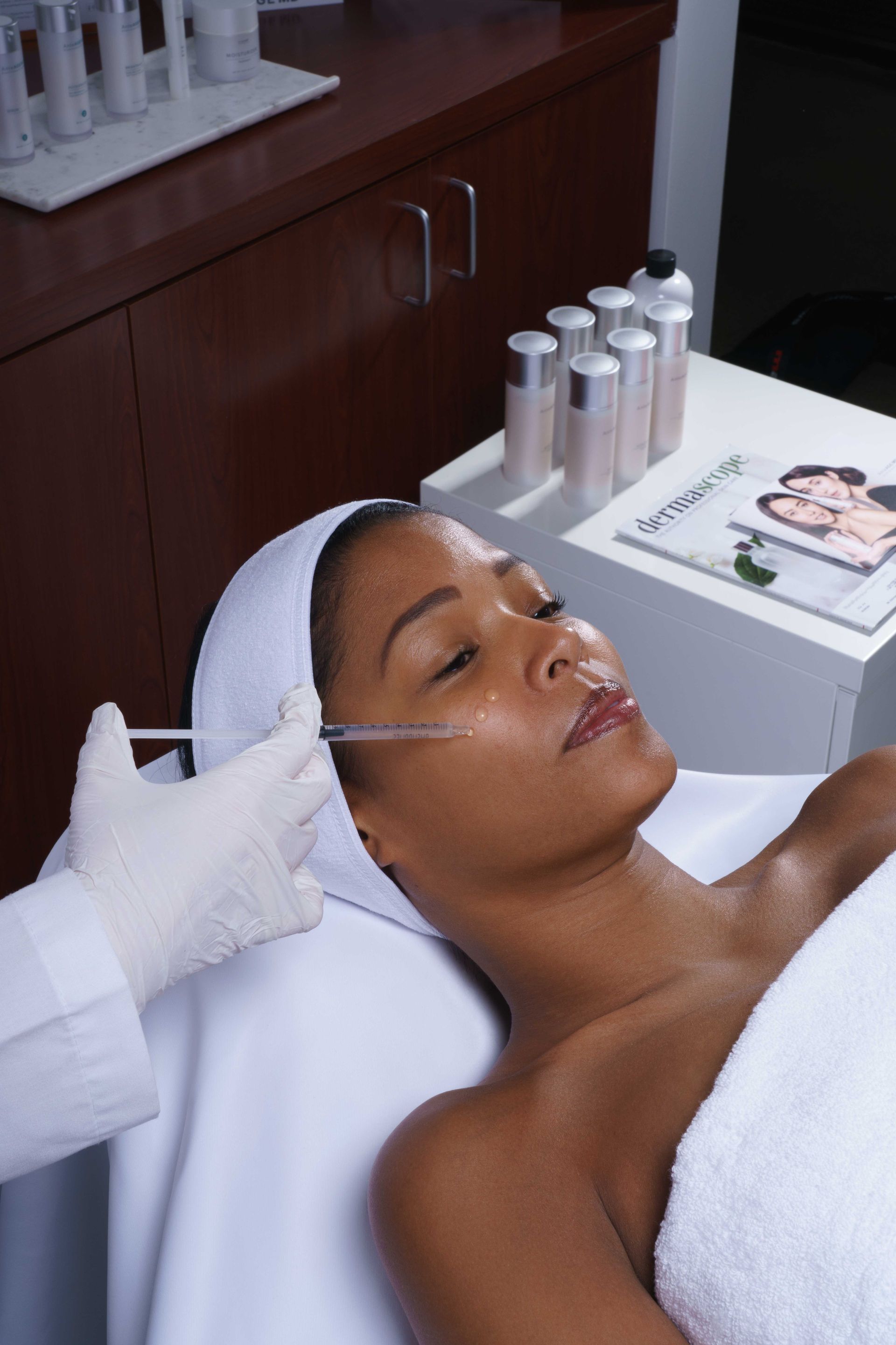 A woman is getting a facial treatment at a spa