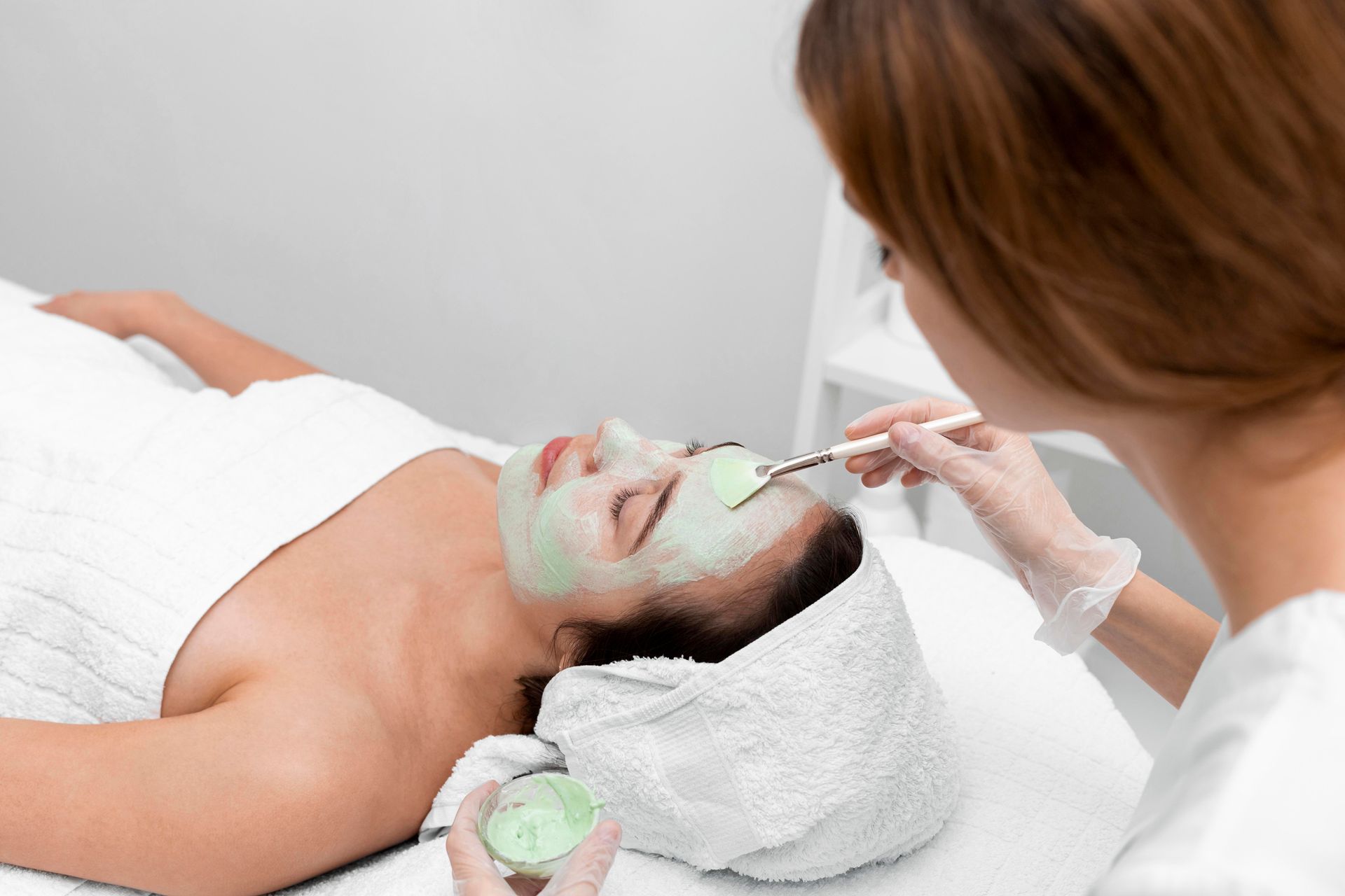 A woman is getting a facial treatment at a spa.